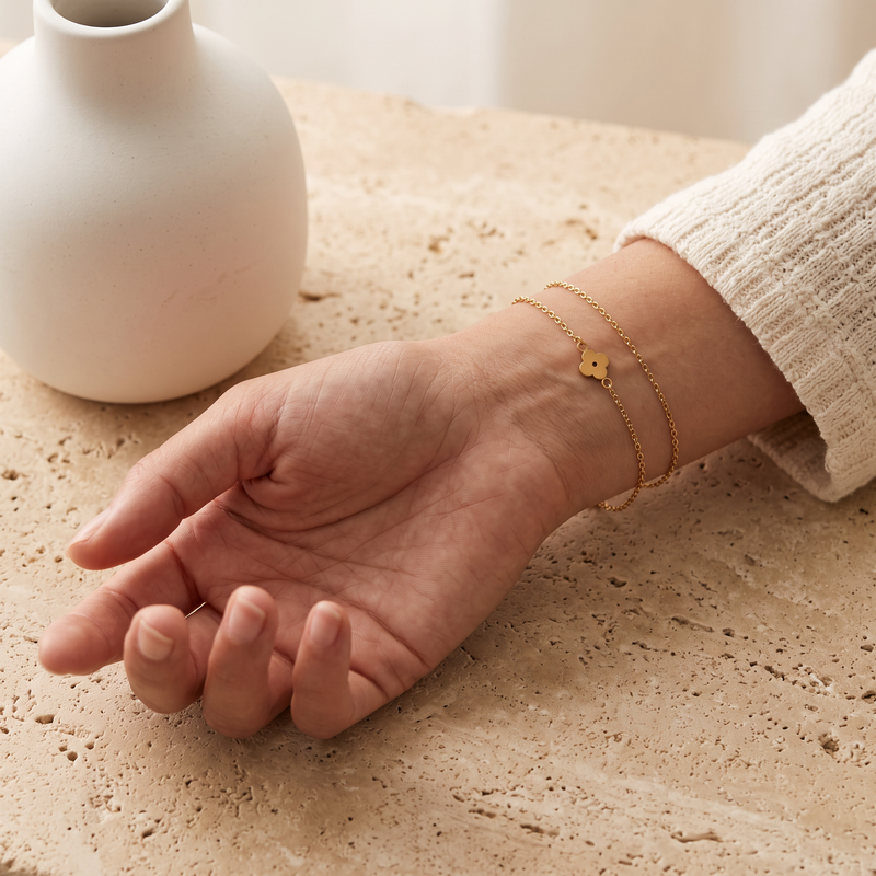 Bracelets dorés sur un poignet près d’un vase