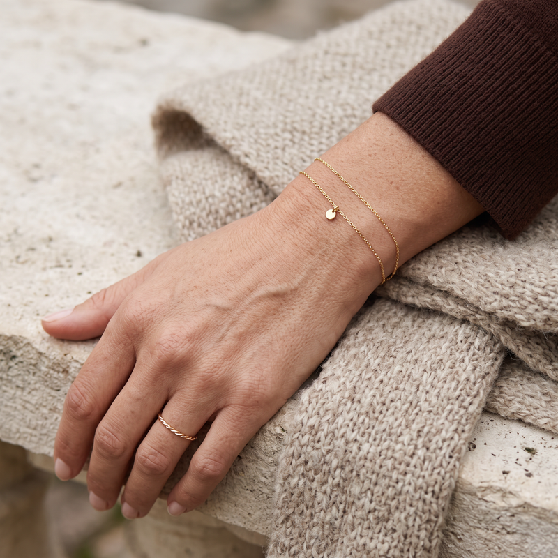 Bracelets fins dorés sur une étoffe naturelle