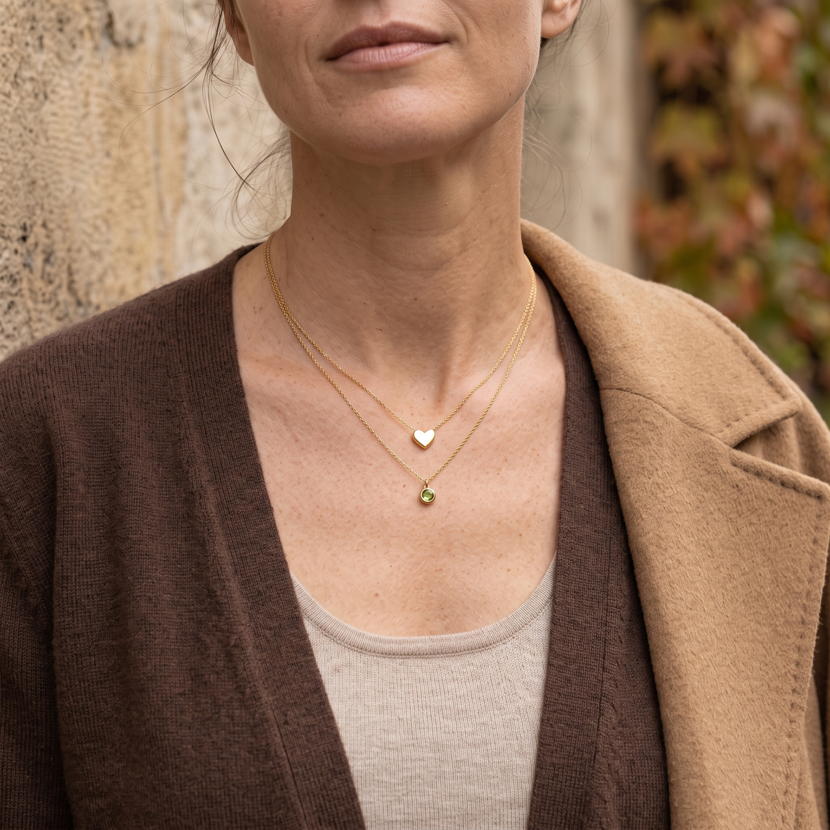 Bijoux dorés portés avec une maille dans une lumière d’automne